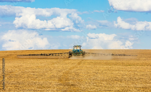 Tractor spraying crops on the prairies
