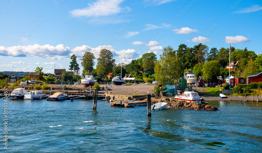 Panoramic view of Lindoya island on Oslofjord harbor near Oslo, Norway, with Lindoya Ost marina and summer cabin houses at shoreline in early autumn