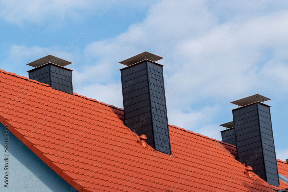 chimney on blue house with red roof in Europe chimney on blue house with red roof in Europe
