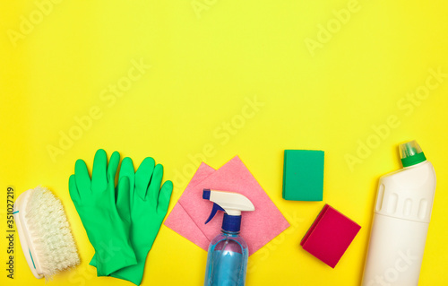 Cleaning. Set of cleaning and detergents in bottles on a yellow background, space for text. Disinfection. Flat lay.