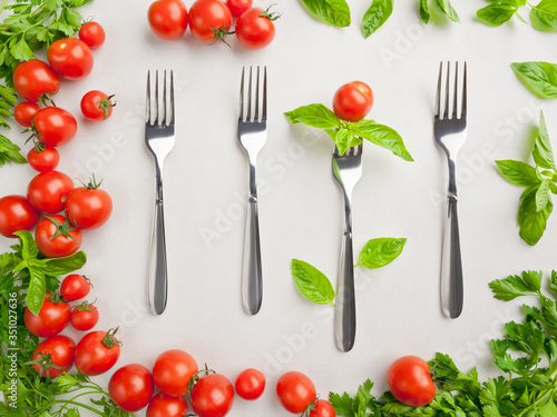Still life with forks, tomatoes and greens
