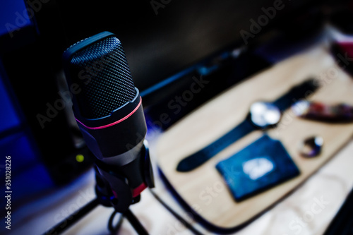 Player microphone on the desk with background blur where you can see a clock and business cards © Tata