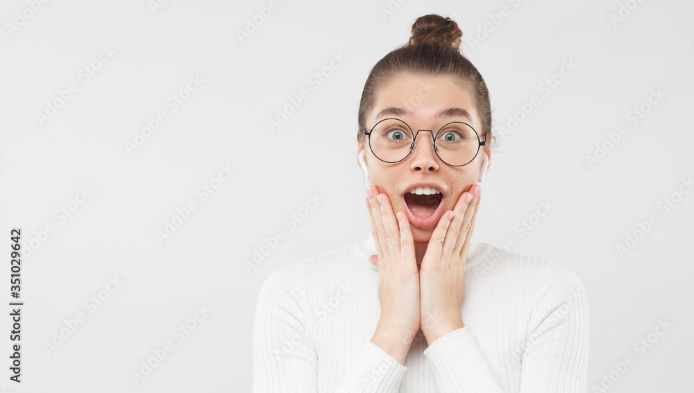 Horizontal banner of young amazed girl feeling surprised and shocked, shouting with OMG WOW face, isolated on gray background, copy space on left Horizontal banner of young amazed girl feeling surprised and shocked, shouting with OMG WOW face, isolated on gray background, copy space on left