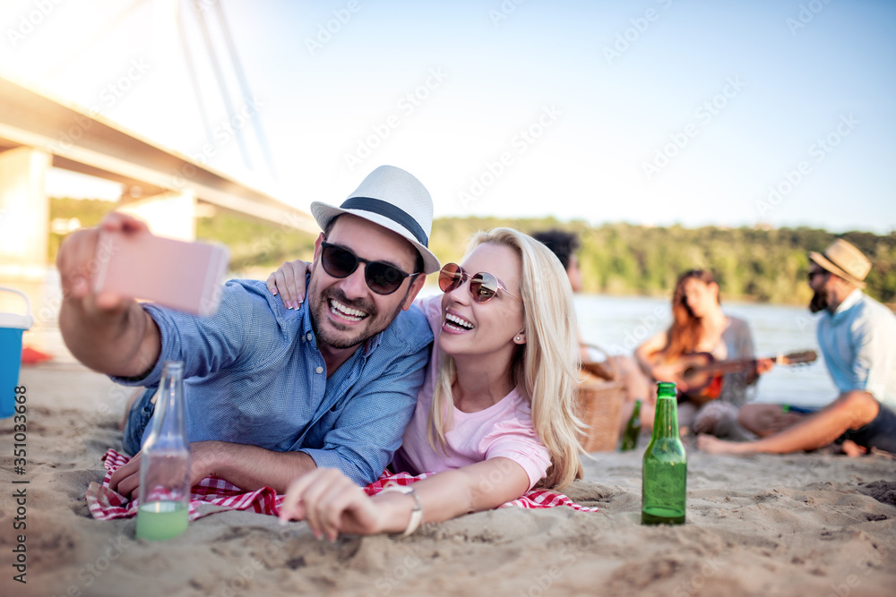 Fototapeta premium Happy young couple take selfie on the beach