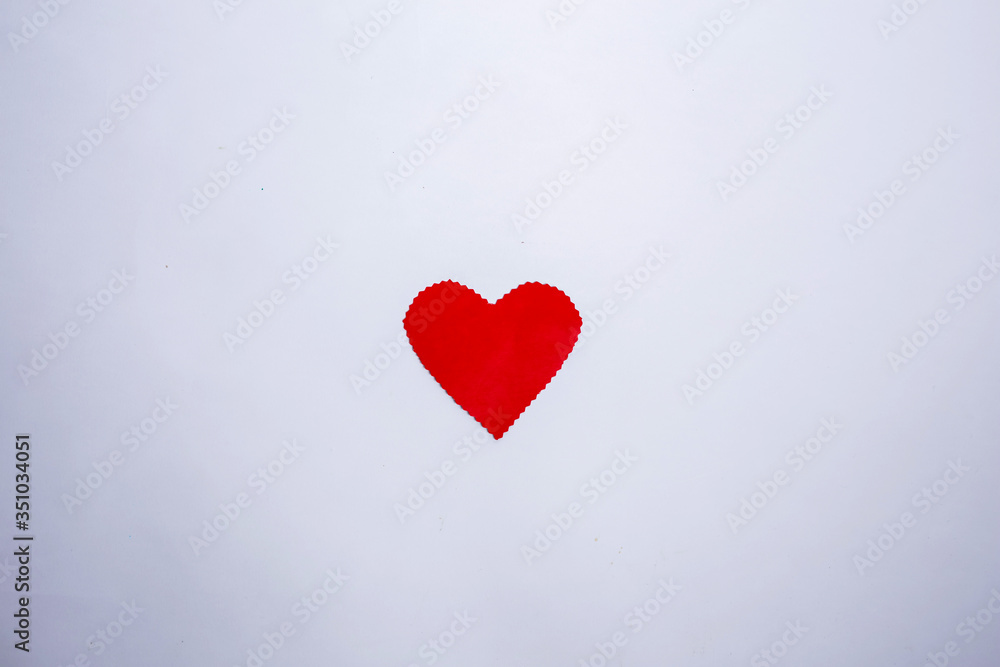 Red cardboard heart with uneven edges on a white background with space for text.