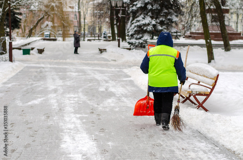 snow storm in the city. Roads and sidewalks covered with snow. Worker shovel clears snow. Bad winter weather. Street cleaning after snowstorm. © Pokoman