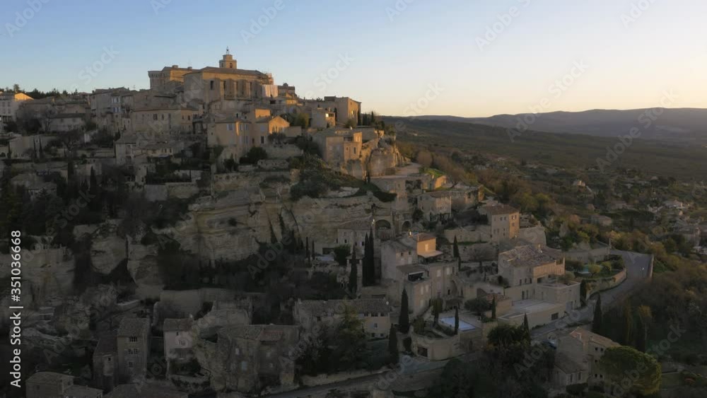 Aerial orbit view of Gordes, France. Sunrise shoot with orange colours bouncing off buildings Aerial orbit view of Gordes, France. Sunrise shoot with orange colours bouncing off buildings