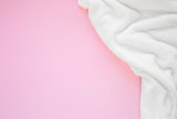 Flat lay white fluffy plaid on a pink background with copy spase. Cozy staing home concept. Top view