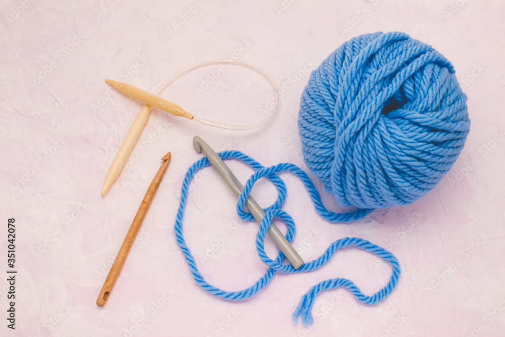 Ball of woolen thread for knitting. With crochet hook and knitting.