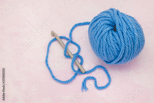 Ball of woolen thread for knitting. With crochet hook and knitting.