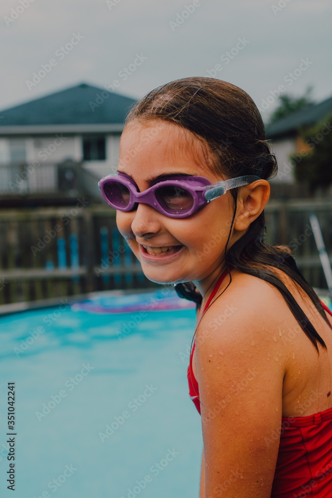 chica joven divirtiéndose en la piscina en un día caluroso de verano con gafas acuáticas en bañador rojo chica joven divirtiéndose en la piscina en un día caluroso de verano con gafas acuáticas en bañador rojo