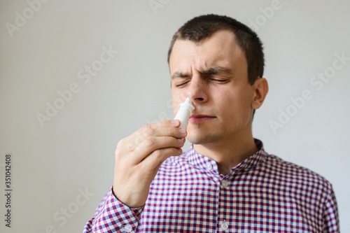  spraying nose drops for treating his allergic or infectious rhinitis photo