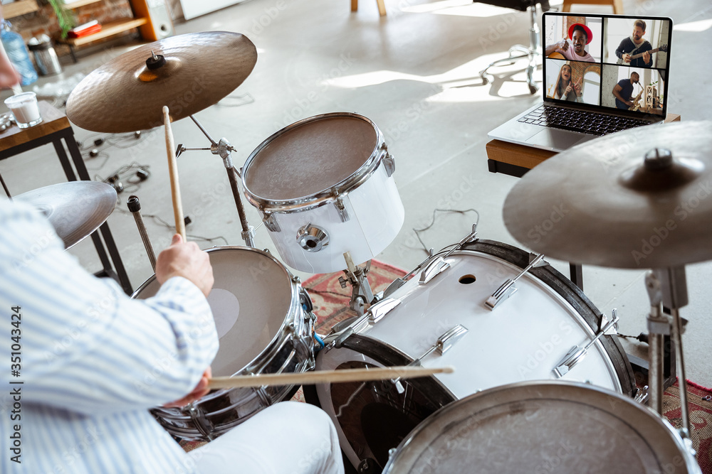 Obraz premium Caucasian musician playing drumms during online concert at home isolated and quarantined. Using camera, laptop, streaming, recording courses. Concept of art, support, music, hobby, education.
