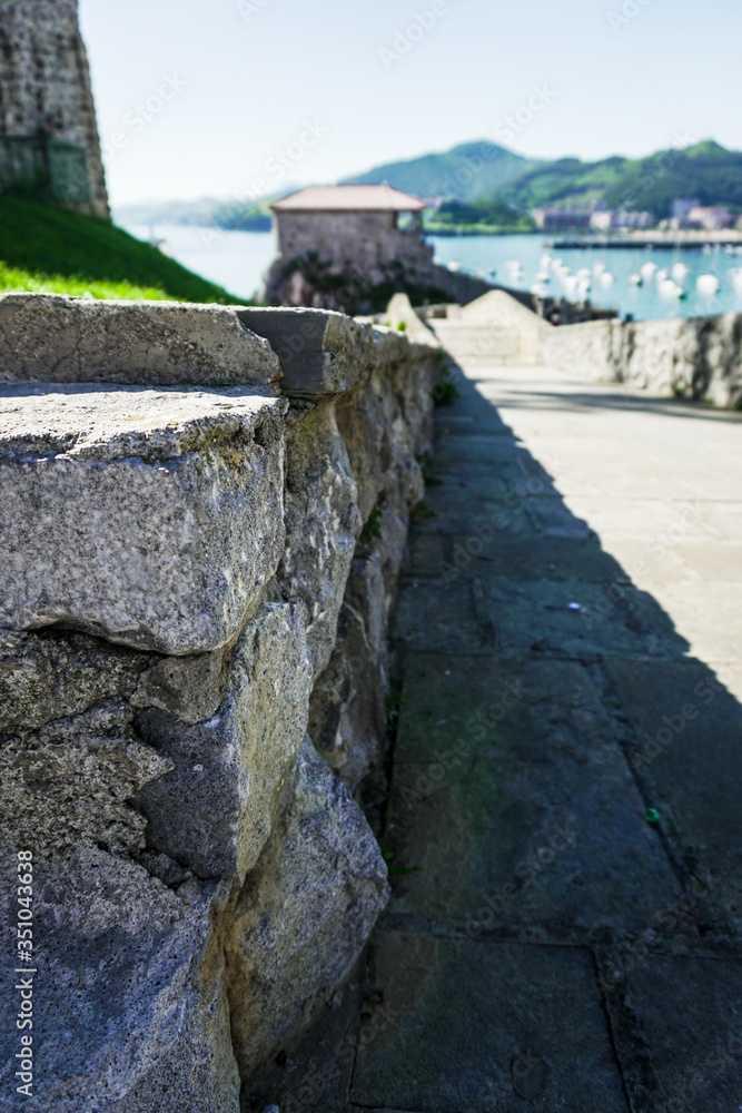 muro de piedra bajo en un camino hacia el mar
