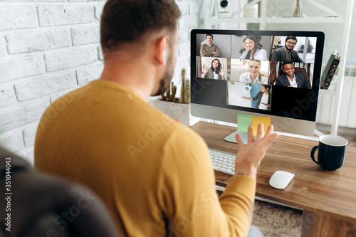 Video conference. Business partners communicate via video conference using computer. The guy talks with his business partners appearance about plans and strategy. Distant work