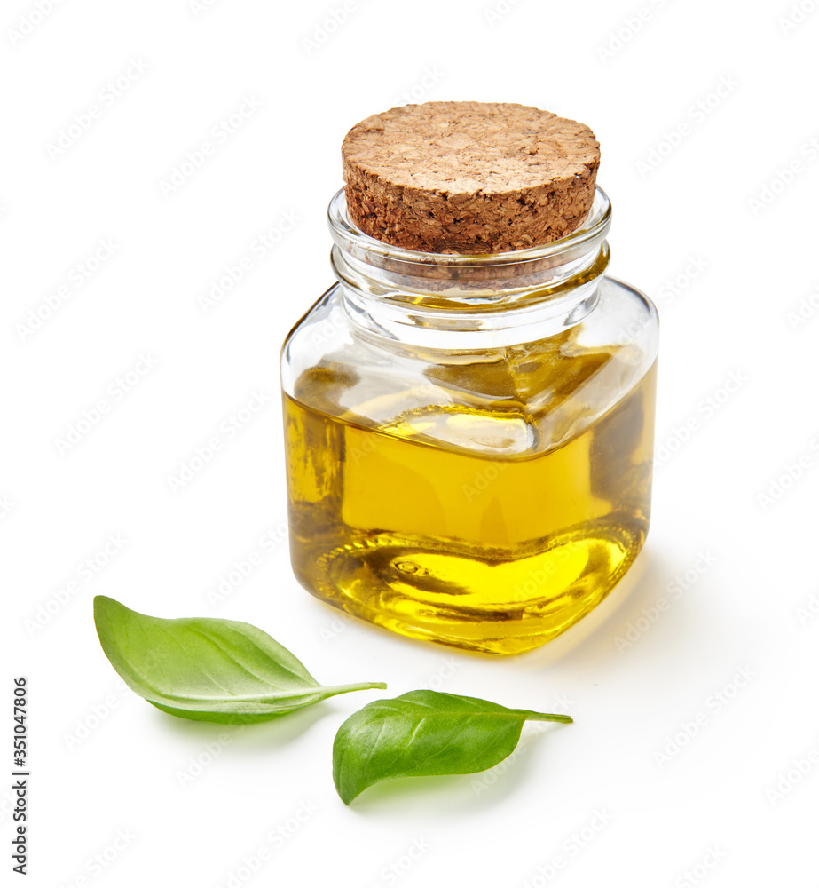 Glass jar of olive or vegetable oil with basil leaves isolated on white. Glass jar of olive or vegetable oil with basil leaves isolated on white.
