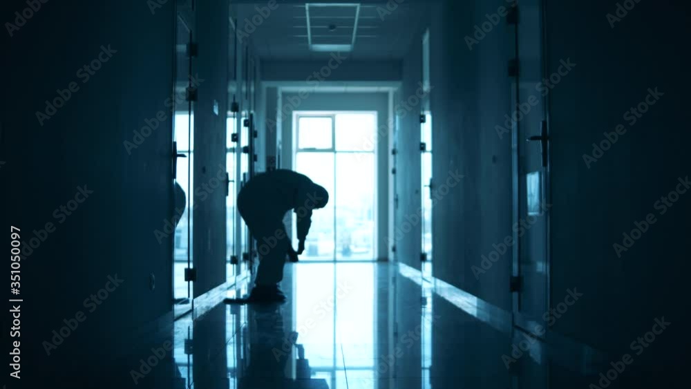 Doctor in a protection suit sits on the floor in the corridor Doctor in a protection suit sits on the floor in the corridor
