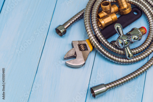 Plumbing tool, faucet and hose on blue wooden boards are used to replace or repair