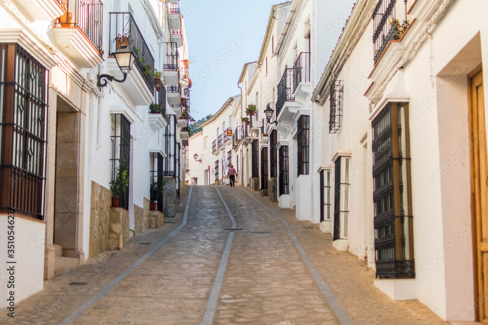 Narrow and cozy street in a white village in Andalusia, Spain.