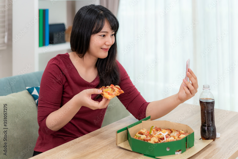 Asian woman virtual happy hour meeting dinner and eating pizza food online together with her boyfriend in video conference with digital tablet for a online meeting in video call for social distancing. Asian woman virtual happy hour meeting dinner and eating pizza food online together with her boyfriend in video conference with digital tablet for a online meeting in video call for social distancing.