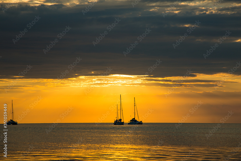 Orange and Black in the sunset with sailboats
