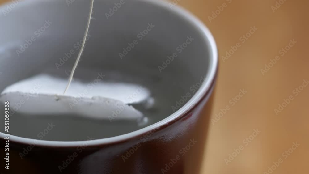 Steam rises over boiling water in a brown porcelain cup for quick preparation of a hot drink for lunch or breakfast. The process of brewing tea or coffee. Close-up Steam rises over boiling water in a brown porcelain cup for quick preparation of a hot drink for lunch or breakfast. The process of brewing tea or coffee. Close-up