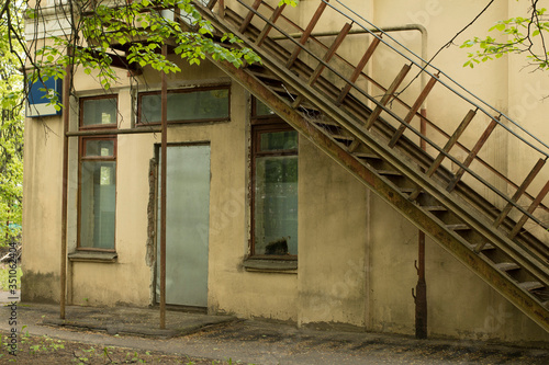 Old abandoned building, metal staircase to the second floor. © Elena