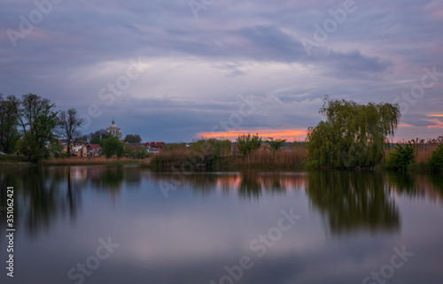 Long exposure sunset view on Ivano-Frankove (Yaniv), Yanivskyi Stav Lake and forest. Roztochia Biosphere Reserve, Lviv district, Ukraine. May 2020 © Сергій Вовк