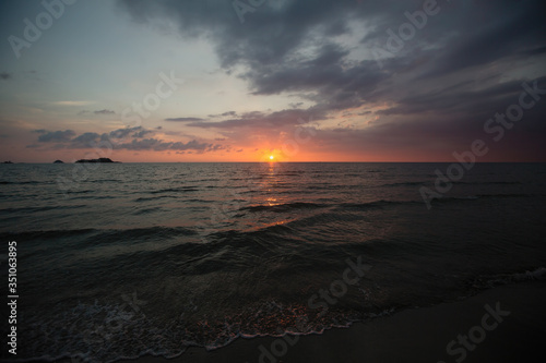 Tropical sea beach against a dusk and blue sky.