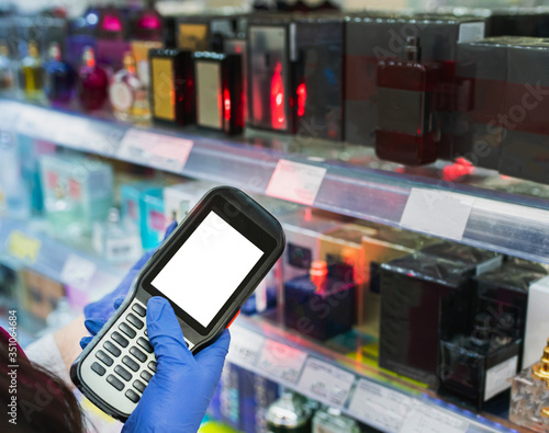 barcode scanner in hand in rubber gloves checks the price of products in the supermarket. close-up view