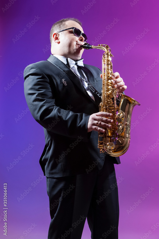 Naklejka premium Music and Musicians Concepts. Portrait of Mature Expressive Caucasian Saxophonist Against Colorful Background.