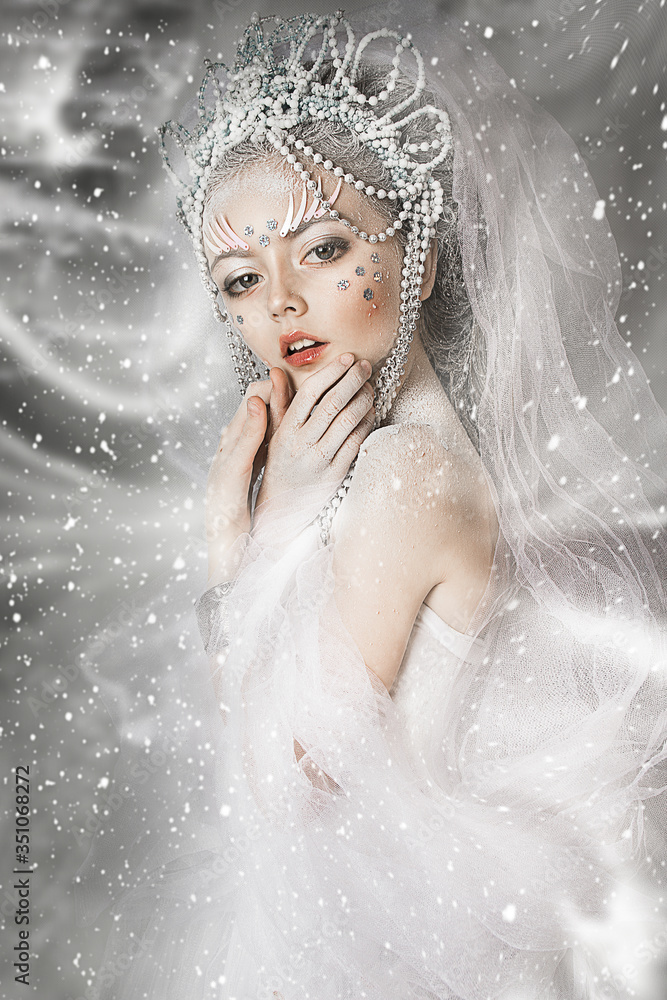 close up portrait of beautiful girl. professional white winter makeup. hair in snow. snow queen with beautiful crown