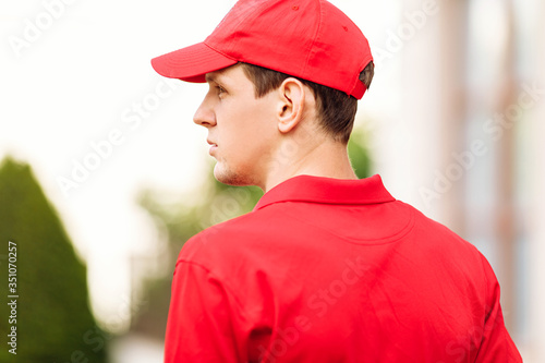 A courier in a red uniform. Online stores and Express delivery.