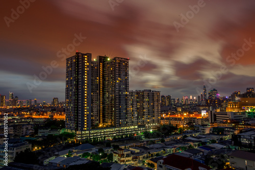 The high angle background of the city view with the secret light of the evening, blurring of night lights, showing the distribution of condominiums, dense homes in the capital community