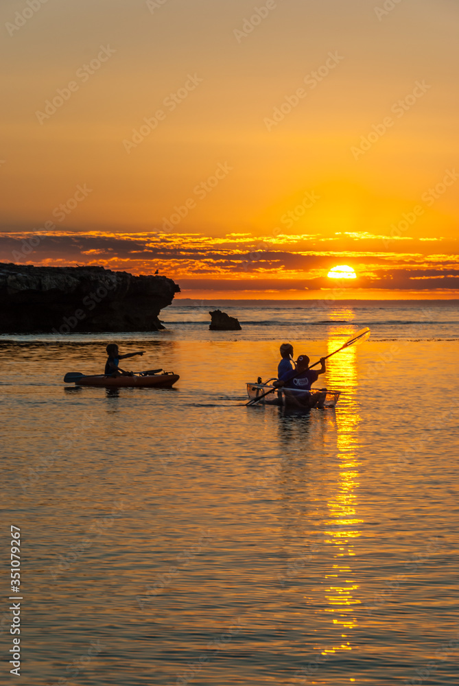 Boys in Canoes at Sunset