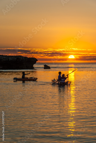 Boys in Canoes at Sunset