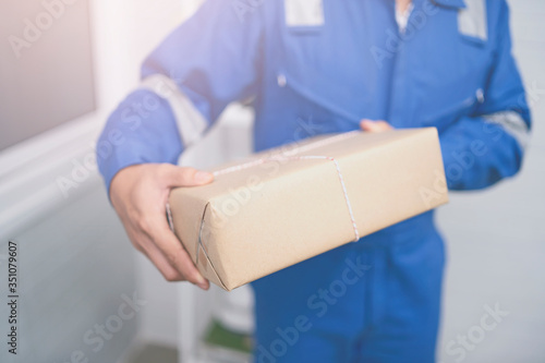 Delivery,mail and shipping,delivery man Checking Portable Device with Asian woman sign in digital Smartphone before receiving parcel or receive package,she appending signature in mobile phone at home.