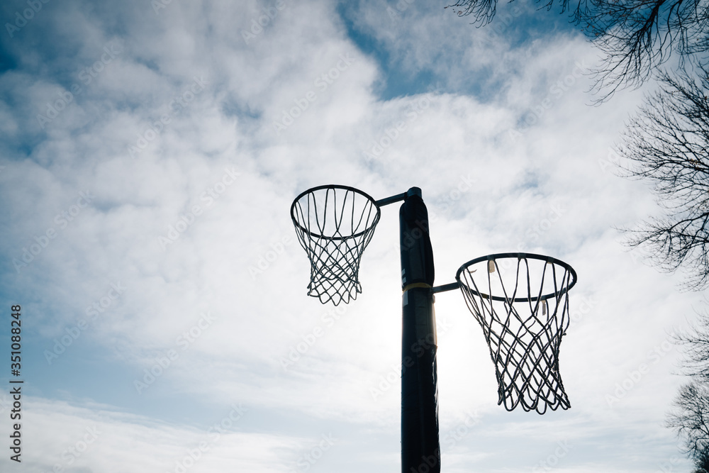 Netball goal ring and net against a blue sky and clouds at Hagley park, Christchurch, New zealand. Netball goal ring and net against a blue sky and clouds at Hagley park, Christchurch, New zealand.