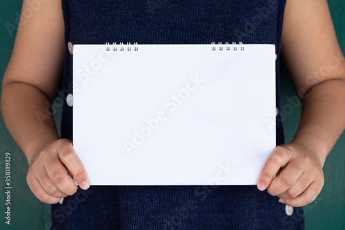 Woman showing blank white calendar,  Leaflet presentation. clear offset paper. Sheet template.