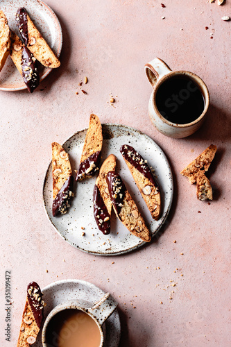 Chocolate dipped hazelnut biscotti with a mug of black coffee. photo