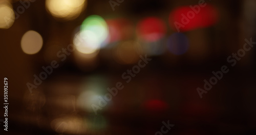 Abstract colorful defocused bokeh background. Blurred City street lights and reflections in rain at night.