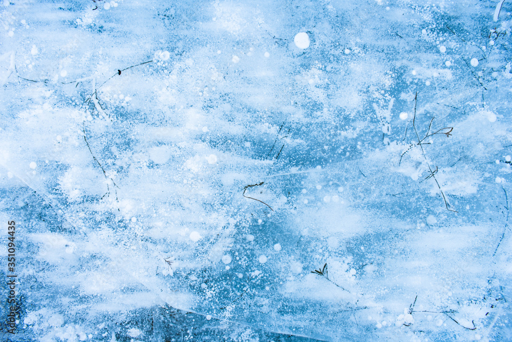 Background. Ice with bubbles and dry grass.