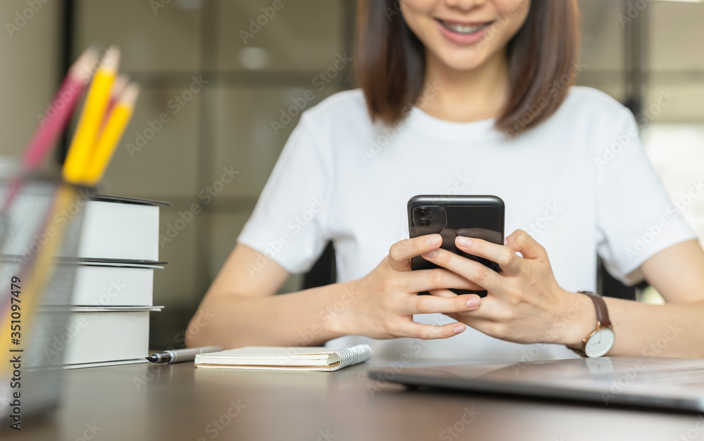 Young woman hand holding smartphone and chatting with friends at social network on the table. Young woman hand holding smartphone and chatting with friends at social network on the table.