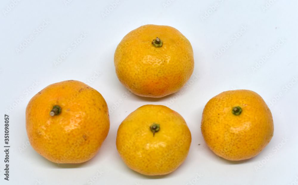 Many yellow tangerine ripe fruit is placed isolated on a white background. Many yellow tangerine ripe fruit is placed isolated on a white background.