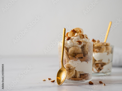 trifle dessert with banana, mascarpone, cookies and almonds photo