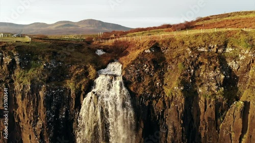 Pull back Aerial drone shot of mealt falls waterfall in Isle of Skye Scotland crashing water into the sea photo