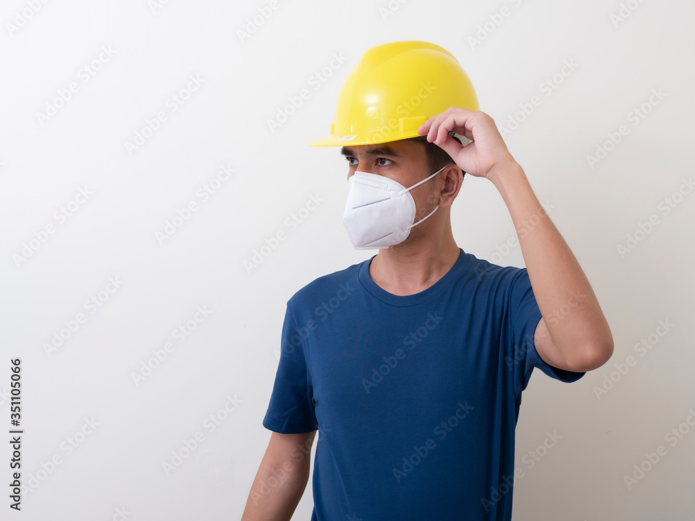 Asian industrial workers wear yellow hard hats, wear protective masks for their healtha