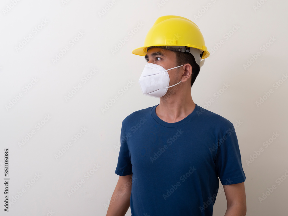Asian industrial workers wear yellow hard hats, wear protective masks for their healtha Asian industrial workers wear yellow hard hats, wear protective masks for their healtha