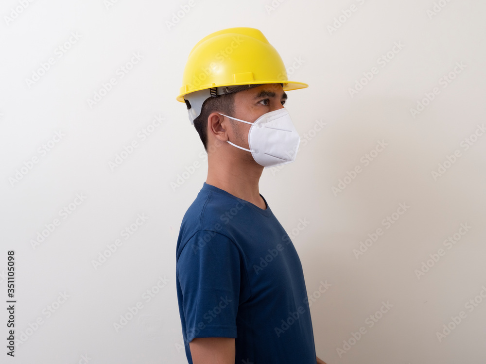 Asian industrial workers wear yellow hard hats, wear protective masks for their health Asian industrial workers wear yellow hard hats, wear protective masks for their health
