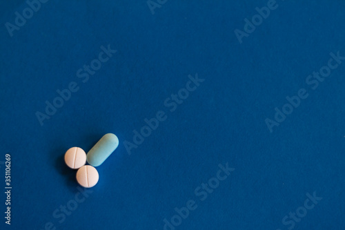 Representation of male genitalia with pills. Penis formed with pills on blue background.